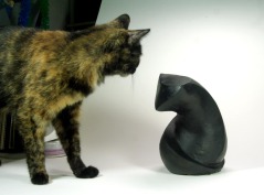 tortie cat and sculpture