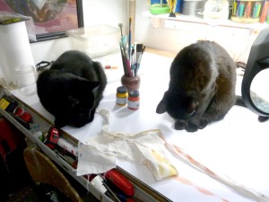 two black cats with art materials